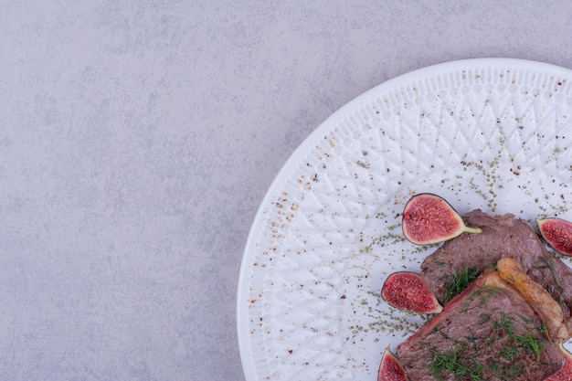 Foto gratuita due fette di bistecca di carne con erbe e spezie