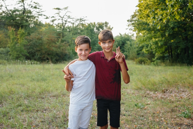 Два маленьких веселых мальчика стоят в парке и улыбаются. счастливое детство.