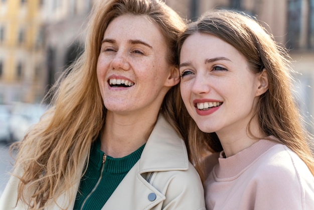 Two smiley female friends outdoors in the city