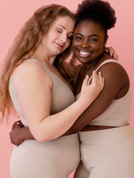 Two smiley women posing while wearing a body shaper