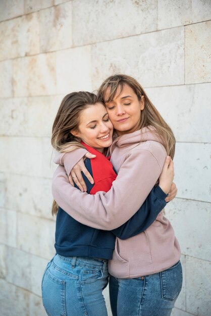 Две улыбающиеся молодые женщины обнимаются