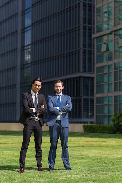 Free photo two smiling adult business men standing outside