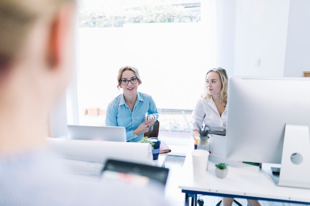 Two smiling businesswoman sitting in meeting at office