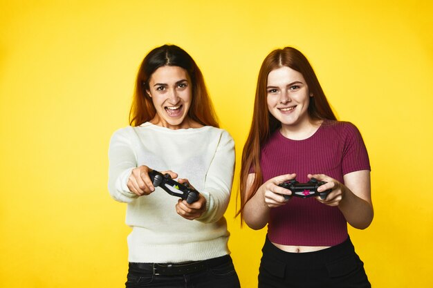 Two smiling caucasian girls with wireless joystick