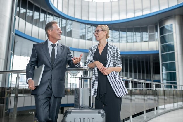 Two smiling entrepreneurs standing at the airport terminal