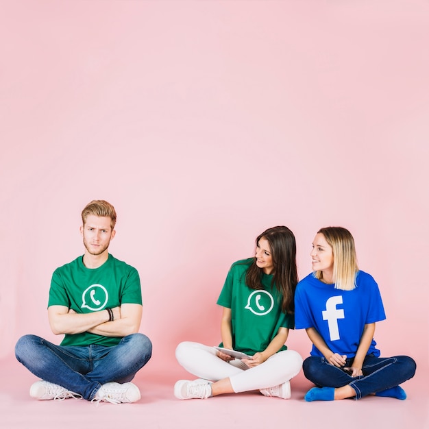 Two smiling female friends looking at an upset man