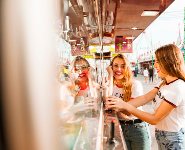 Two smiling female friends playing toy grabbing game