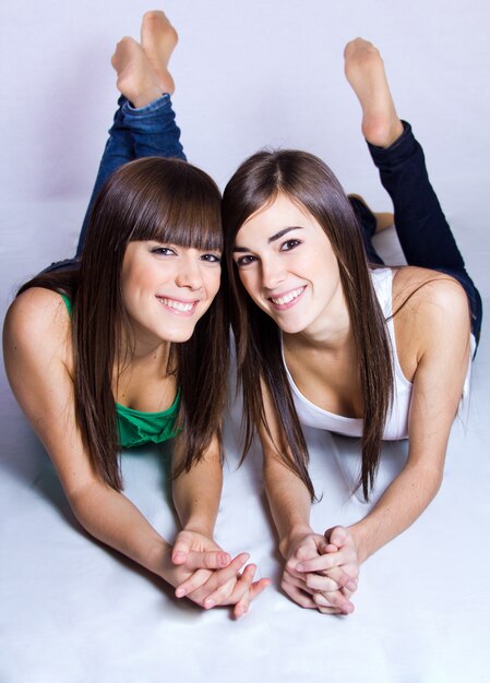 Two smiling girls lying on the floor