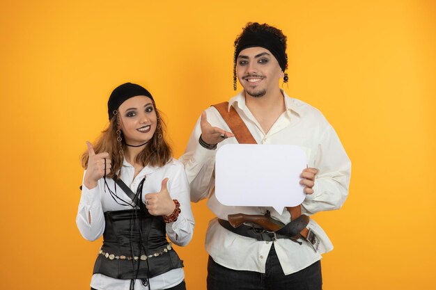 Two smiling Pirates holding idea board and gesture thumb up. High quality photo