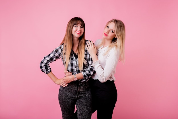 Two smiling women hugging and standing together