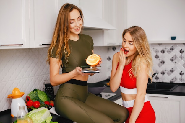 Две спортивные девушки на кухне с овощами
