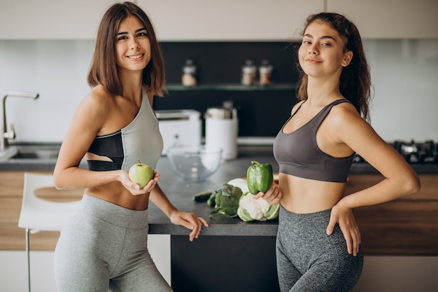 Две спортивные девушки на кухне готовят еду