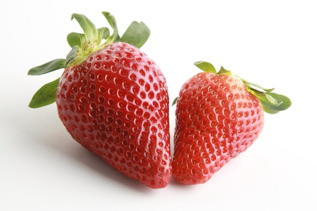 Two strawberries on a white surface