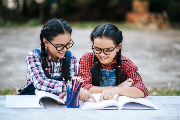 Two students studying together online with a laptop in the park