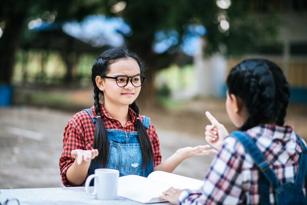 公園でお互いに話している2人の勉強の女の子