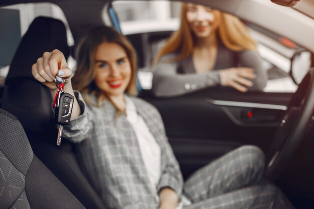 Two stylish women in a car salon