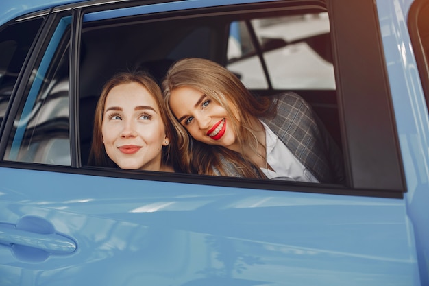 Free photo two stylish women in a car salon