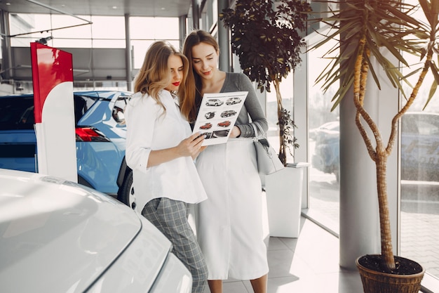 Two stylish women in a car salon