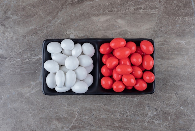 Two sweet candies in the cup on the towel on the marble surface