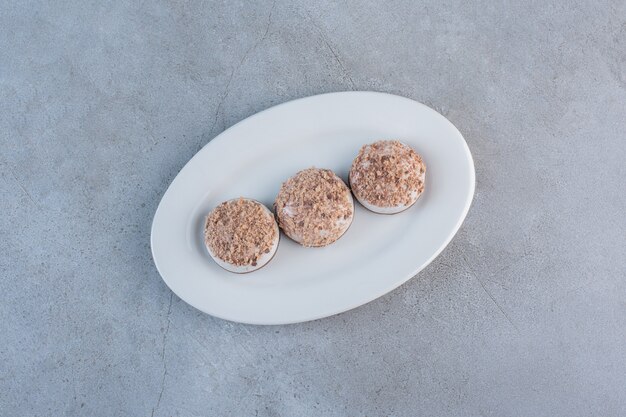 Two tasty truffle balls placed on white plate.