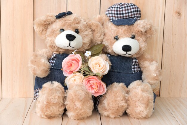 two teddy bears on wood background