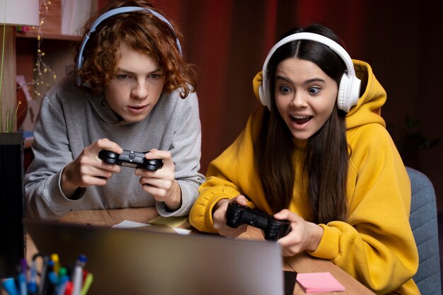 Two teenage friends playing video games together at home