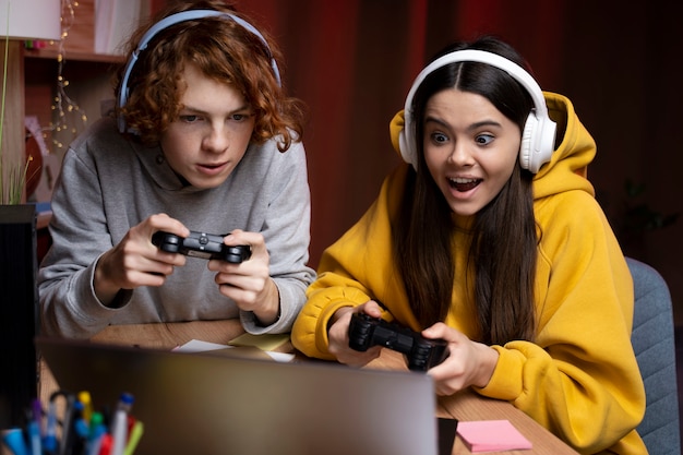 Two teenage friends playing video games together at home