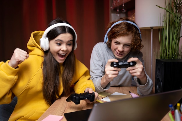 Two teenage friends playing video games together at home