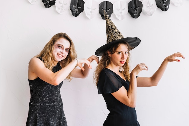 Two teenage girls in Halloween costumes with zombie gestures