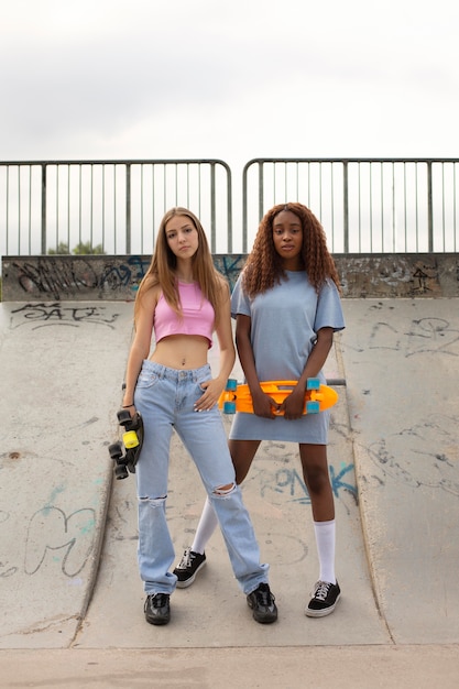 Two teenage girls spending time together in the park at the skating rink