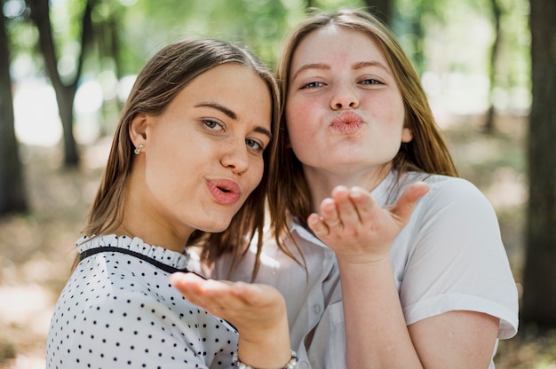 Foto gratuita due ragazze dell'adolescente che saltano i baci