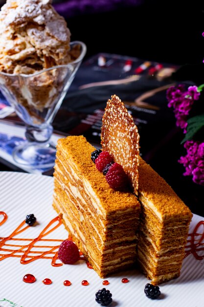Two thin pieces of honey cake garnished with berries