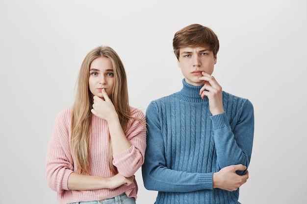 Two thoughtful people, guy and girl thinking, making decision