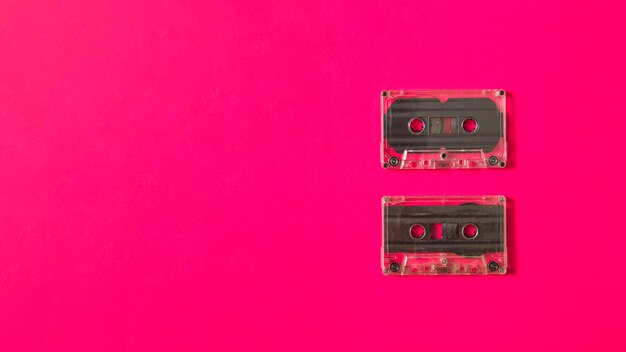 Две прозрачные кассеты на розовом фоне