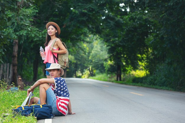 Two travelers sitting on country side street