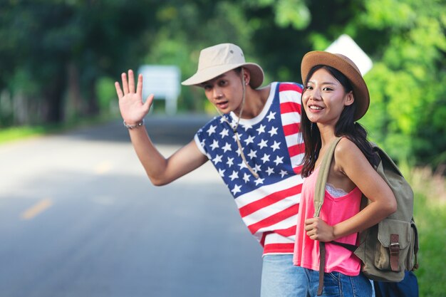 Two travelers walking on country side street