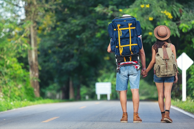 Two travelers walking on country side street