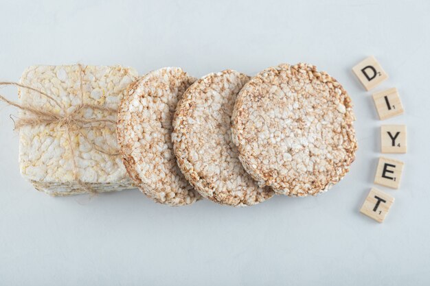 Two types of puffed crispbread tied with rope and wooden letters.