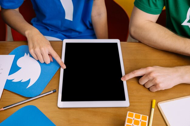 Two users pointing at digital tablet with blank screen