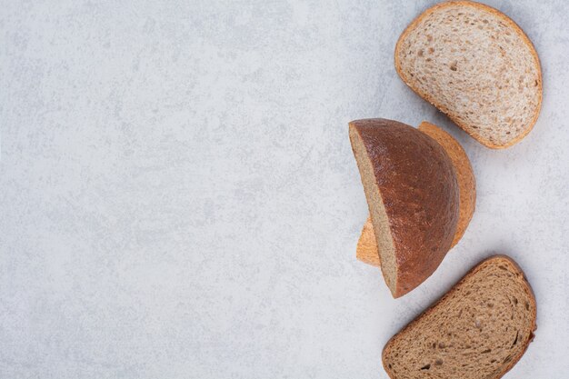 Two variety of bread slices on stone surface