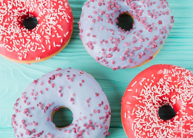 Two various types of delicious donuts on wooden table