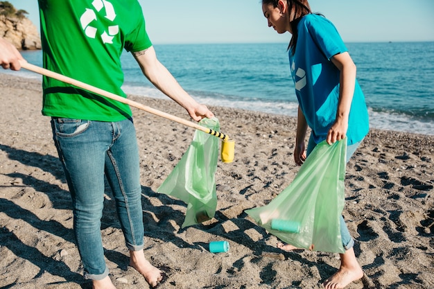 Два добровольца, собирающие отходы на пляже
