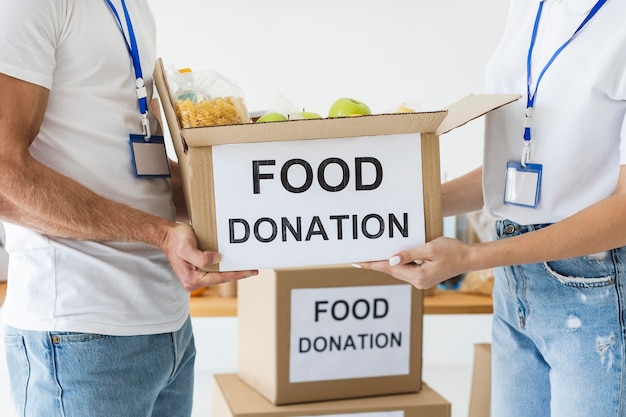 Free photo two volunteers holding food donation box