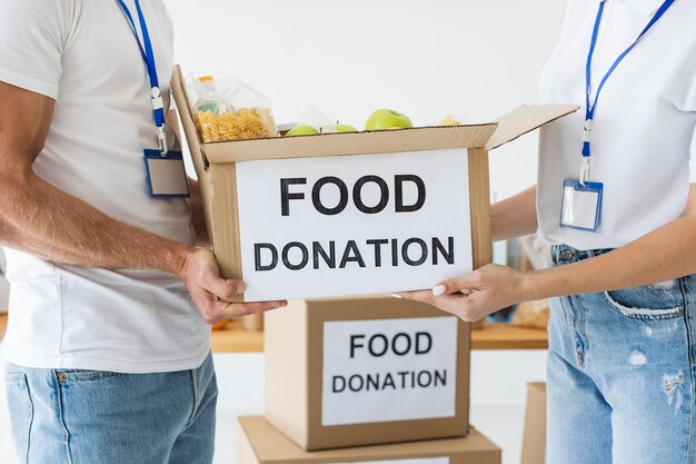 Two volunteers holding food donation box