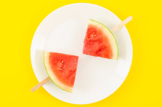 Two watermelon slice popsicles on plate