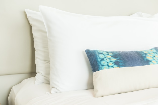 Two white pillows and one blue cushion