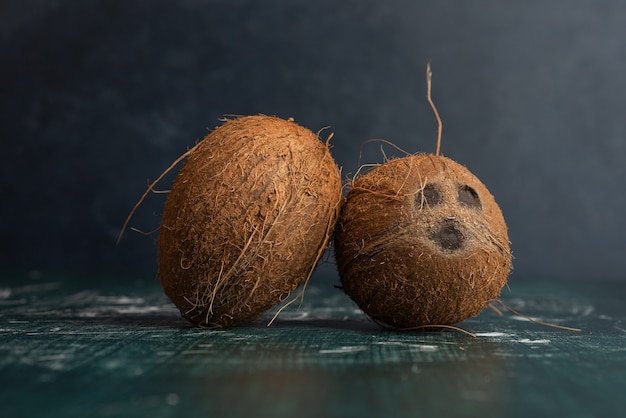 Бесплатное фото Два целых кокоса на мраморном столе.