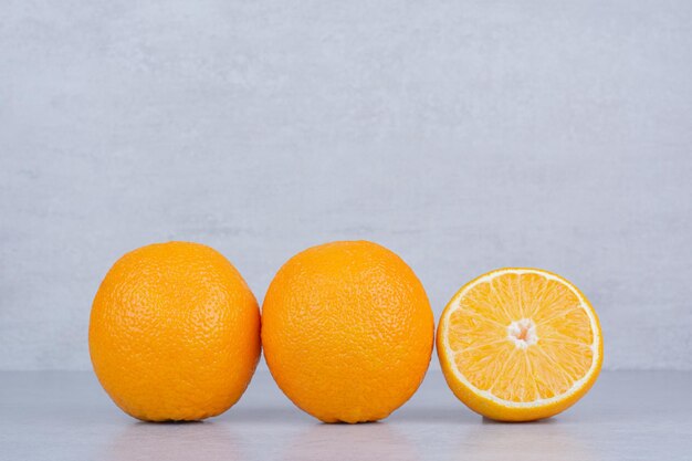 Two whole oranges with slice on white background. High quality photo