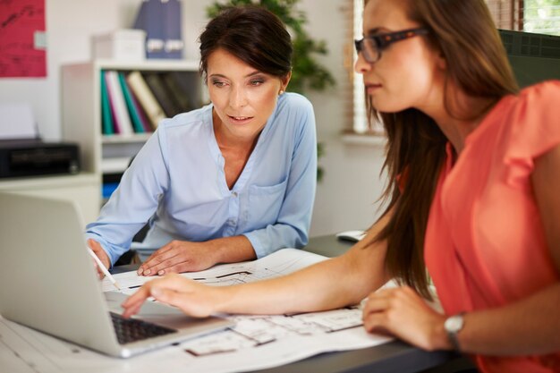 Two women consulting data on the computer