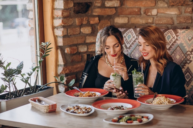 Two women eating pasta in an italian restaurant